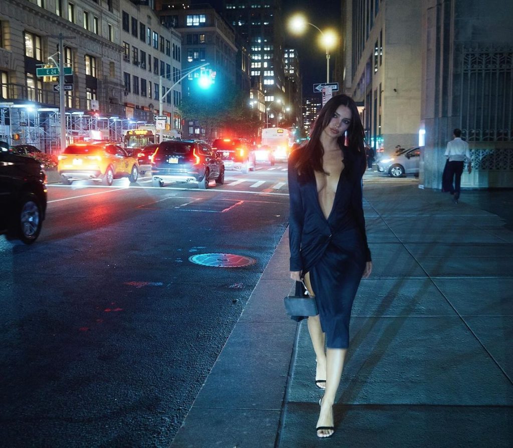 Emily Ratajkowski walking on a public sidewalk in a sexy dress