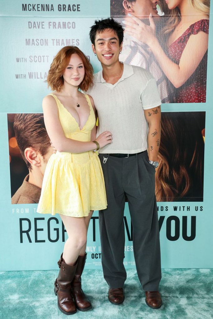 Lily Brooks O'Briant posing next to an Asian guy in front of a movie poster