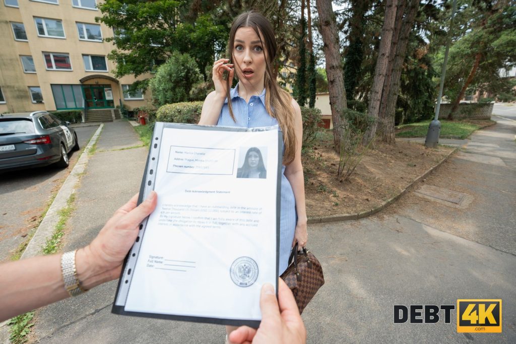 POV with the folder open with a form and the woman looking shocked