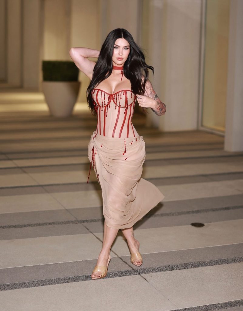 Megan Fox crossing her legs while striking a pose for the camera