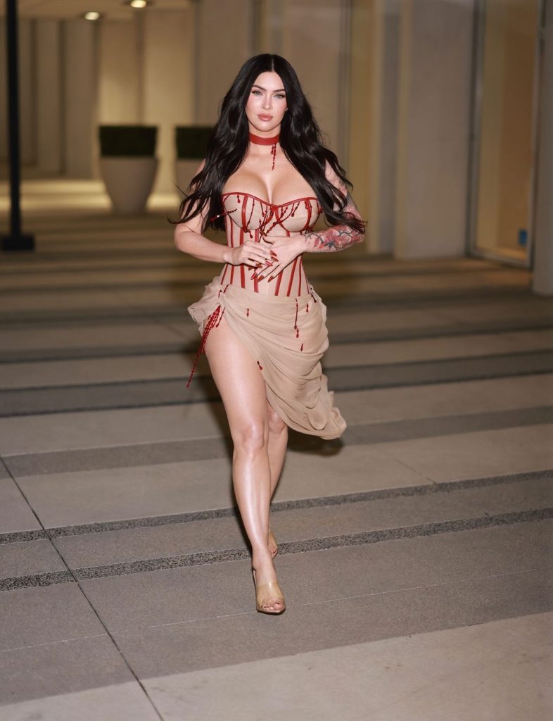 Frontal view of Megan Fox putting one leg forward as she walks