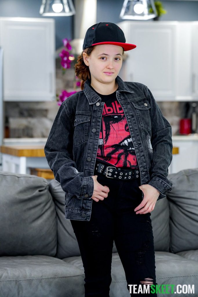 From the knee up frontal view of a redhead tomboy in a rocker outfit