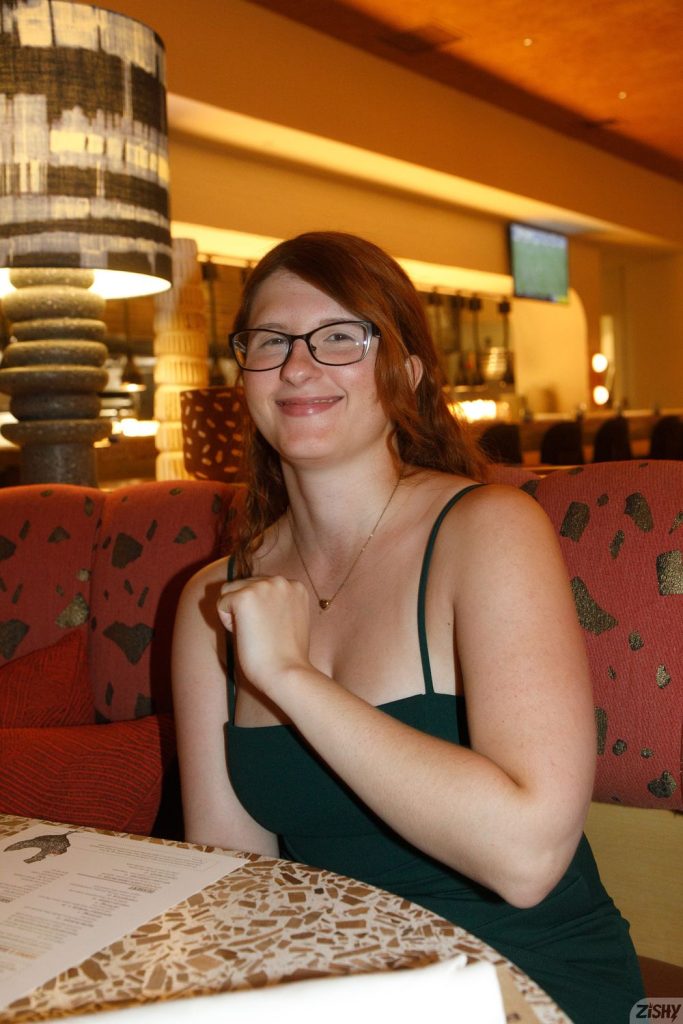 Side angle view of a woman wearing glasses sitting at a restaurant booth