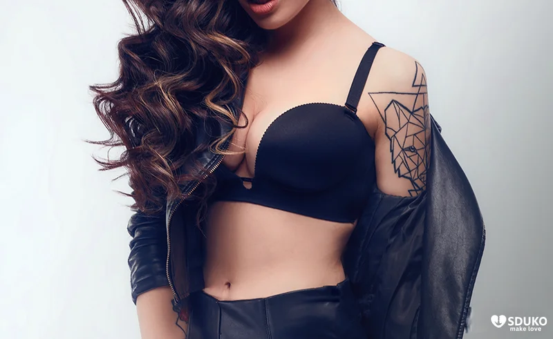 Close up of a woman in an open leather jacket and bra