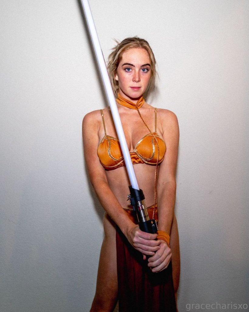 Frontal view of a girl wearing a slave Leia costume and holding a light saber