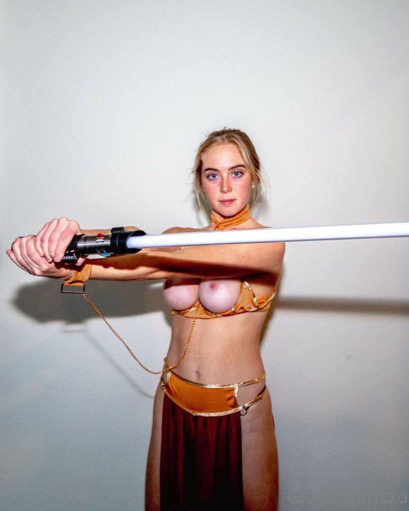 Front view of topless girl in slave Leia costume swinging a light saber