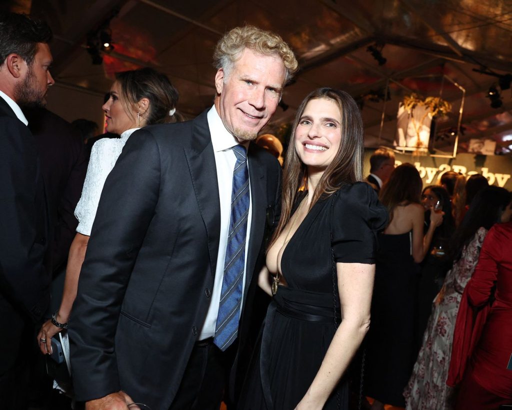 Wide view of Lake Bell turned to the side while posing next to Will Ferrell at a party