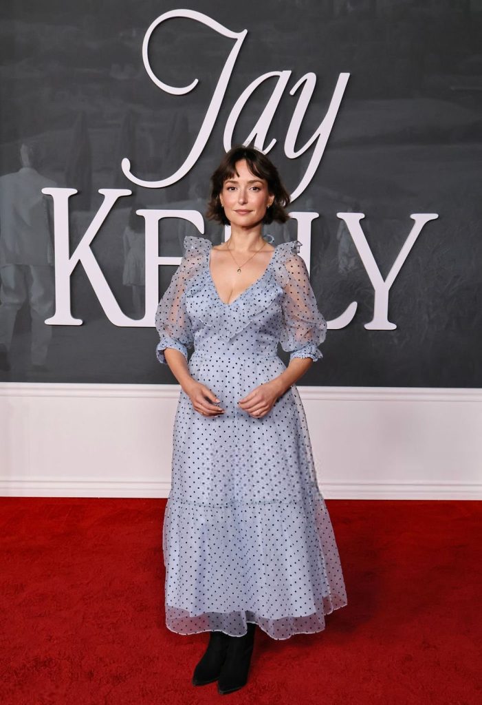 Full body frontal view of Milana Vayntrub holding her hands together