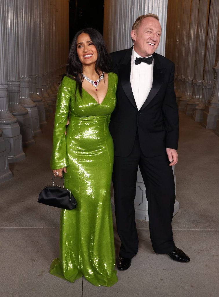 Salma Hayek and her husband laughing together in front of street lights