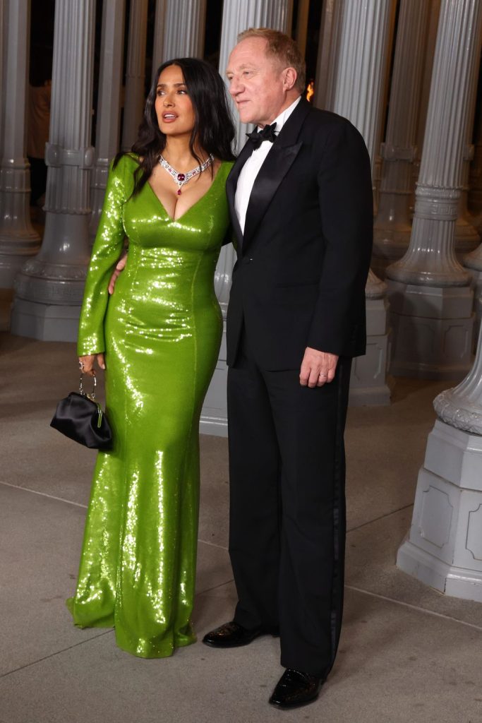 Salma Hayek fronting the camera while her husband is at an angle