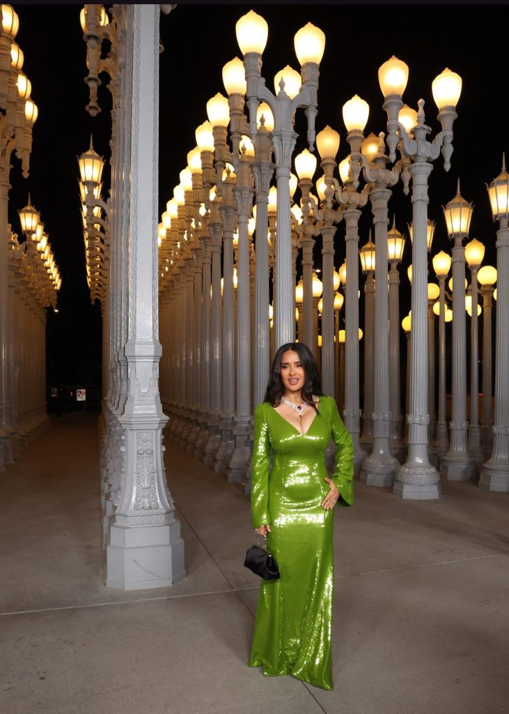 Far away view of Salma Hayek in front of rows of street lights