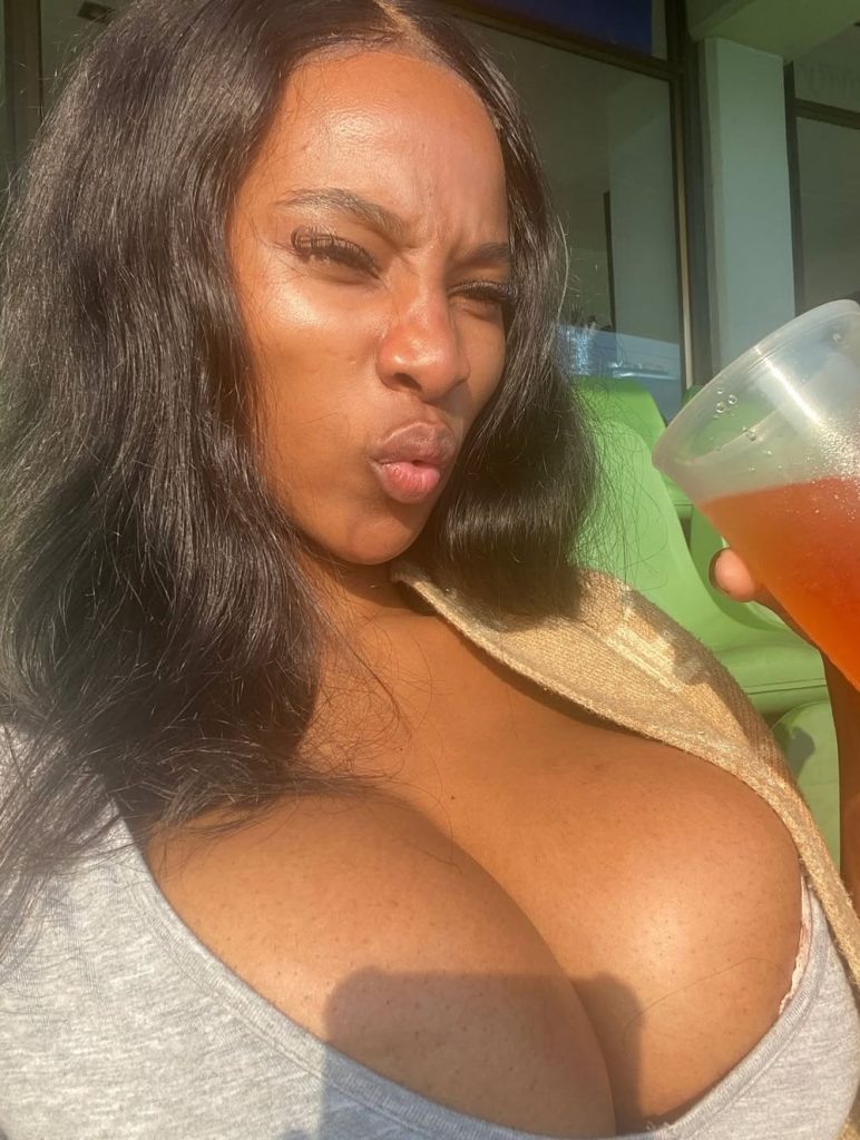 Close up of black girl's face making a sour expression and her big breasts