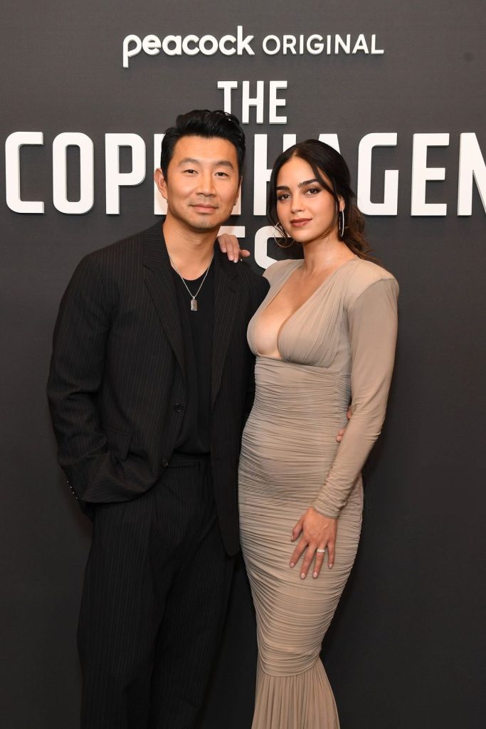 Frontal of Melissa Barrera posing next to an Asian man