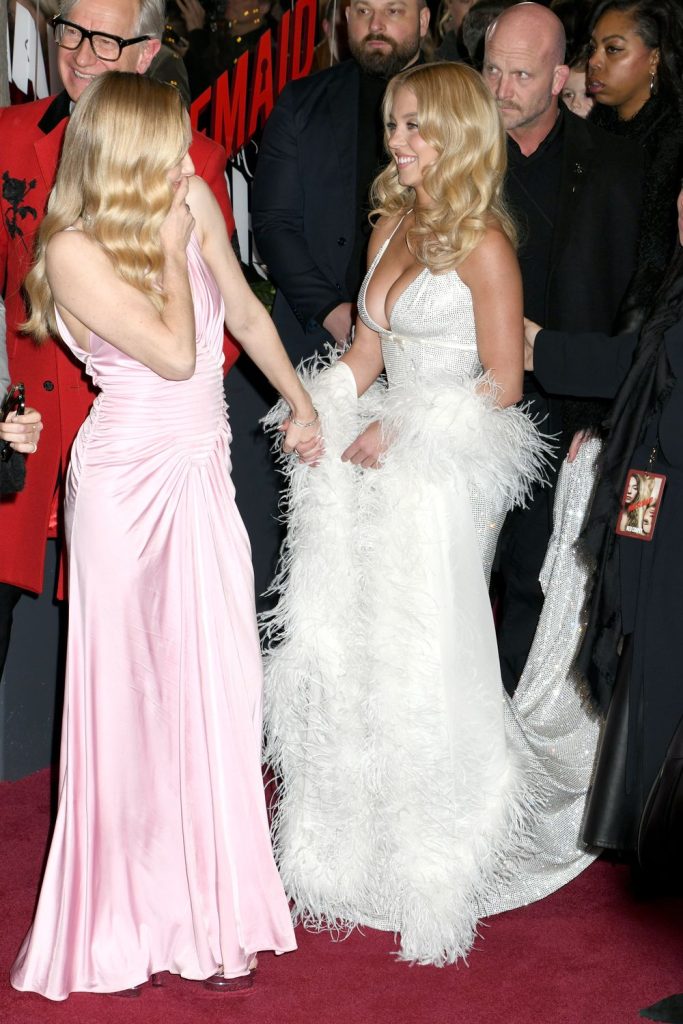 Side view of Sydney Sweeney and Amanda Seyfried interacting on the red carpet