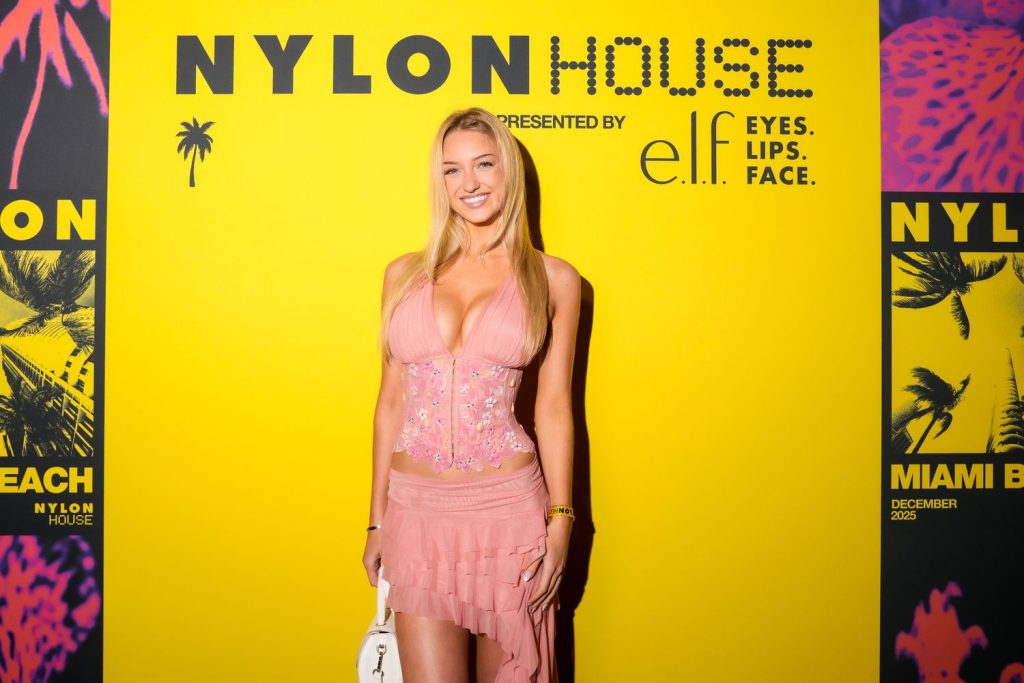 Cropped from knees up view of smiling blonde against a yellow background