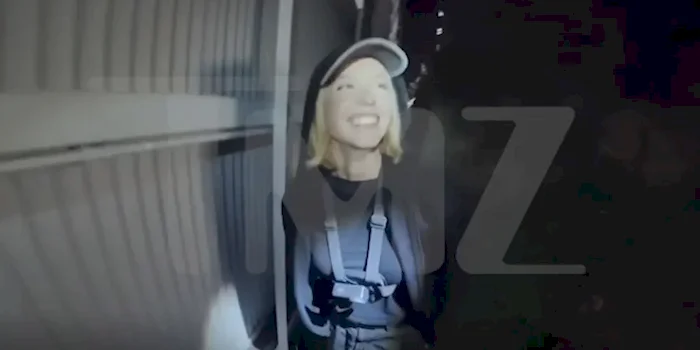 Screen capture of Sydney Sweeney smiling next to the Hollywood sign