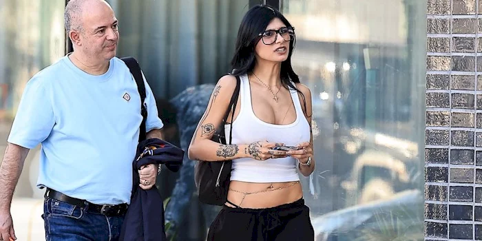 Cropped view of Mia Khalifa in public as she walks next to a man on the sidewalk