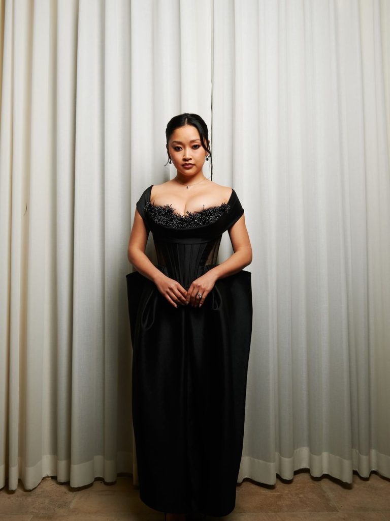 Full body frontal of Asian woman posing in front of a big curtain