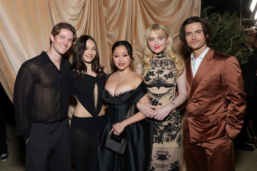 Cropped frontal of two men and two women looking into the camera while posing in fancy clothes at an event