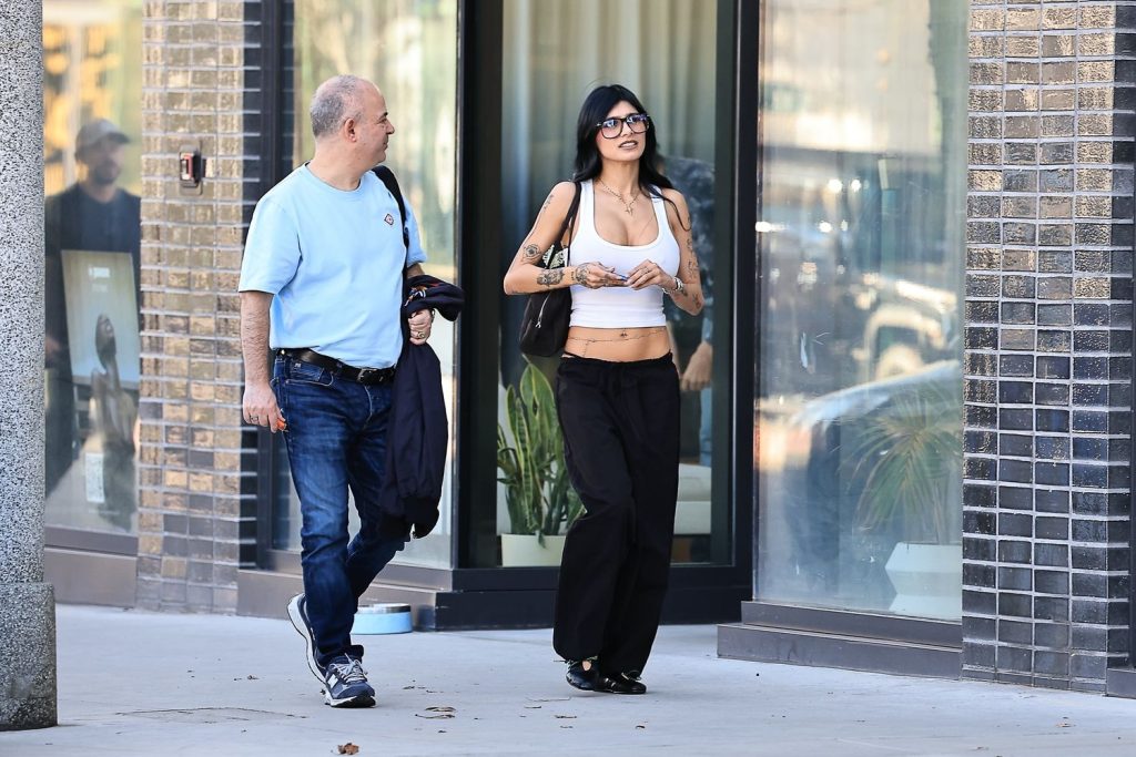 Man and a woman walking next to shop windows on a sidewalk