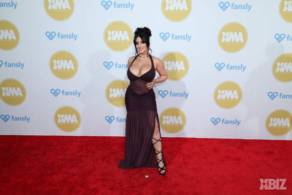 Far away frontal of porn star in sexy dress on the red carpet