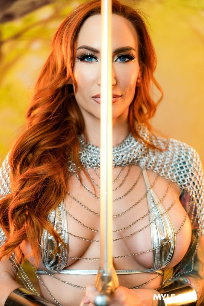 Close up of woman holding a sword up to her face