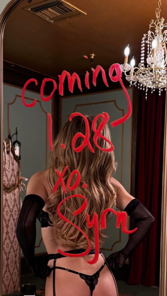 Sydney Sweeney showing her backside in a mirror with written text on it