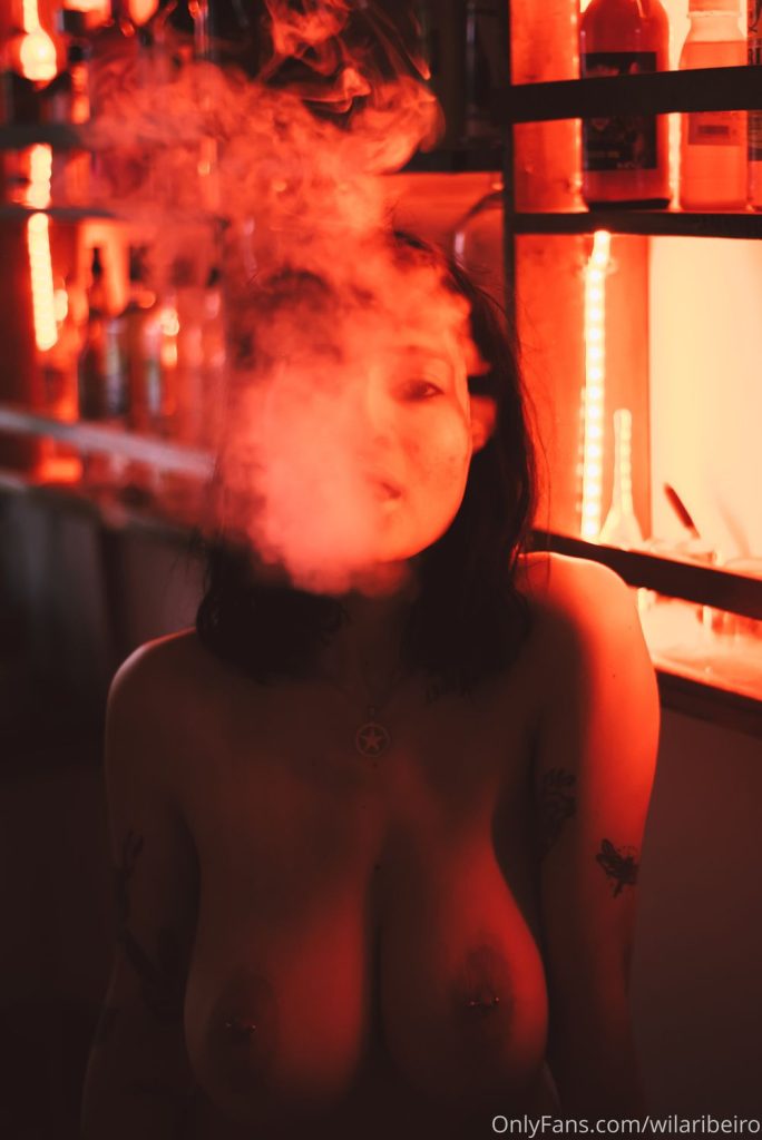 Big puff of smoke covering topless woman's face