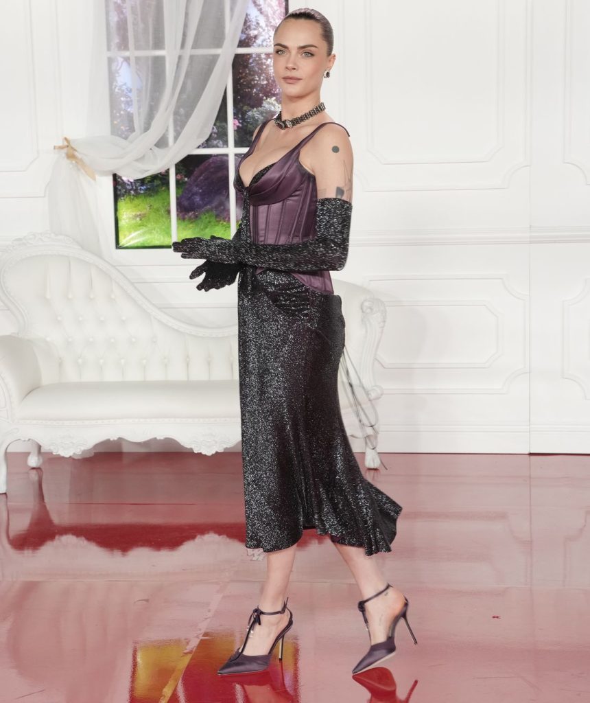 Cara Delevingne walking into a room with a beautiful couch and window