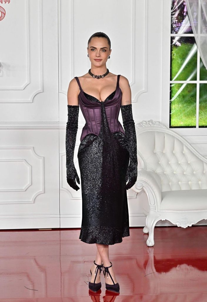Cara Delevingne wearing a corset style dress while posing in a fancy looking room