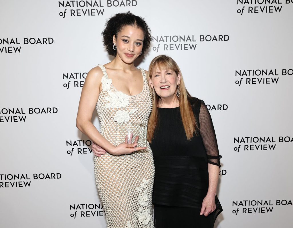 Frontal of Chase Infiniti posing next to an older woman