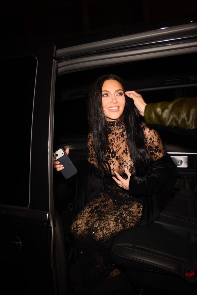 Kim Kardashian smiling while sitting in a car