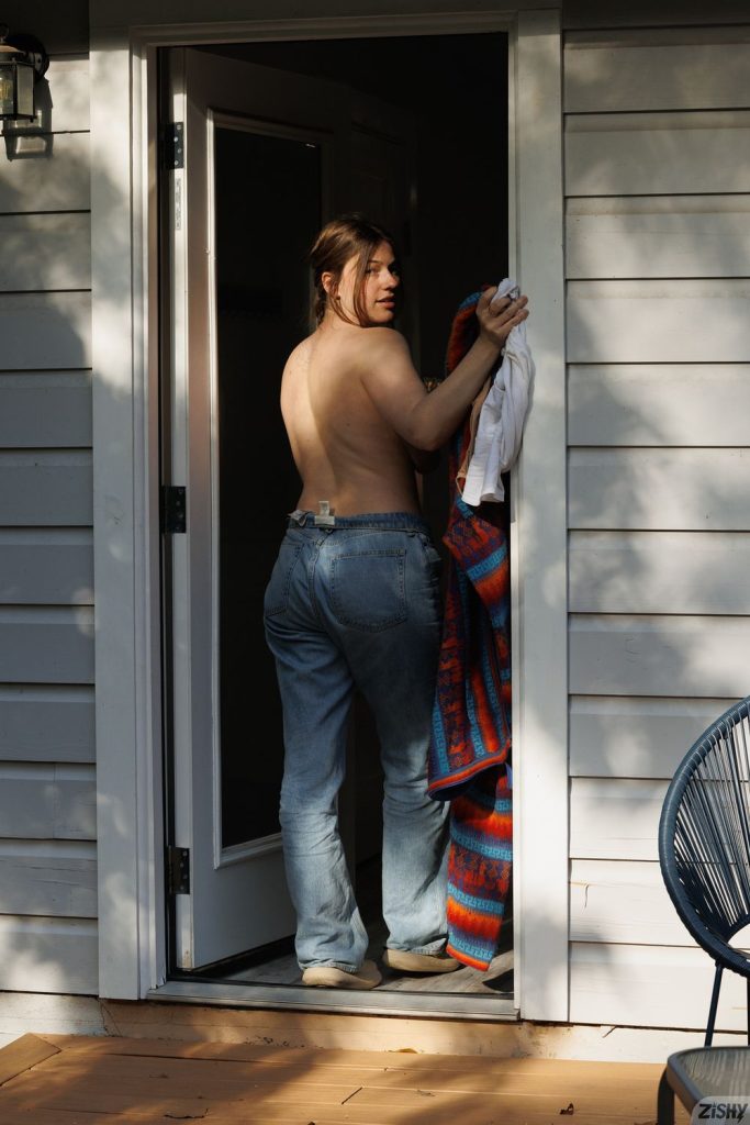 Full body backside view of topless girl entering a house and looking back