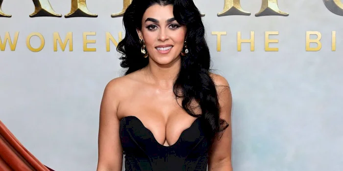 Close up of a smiling woman with dark hair looking directly into the camera.