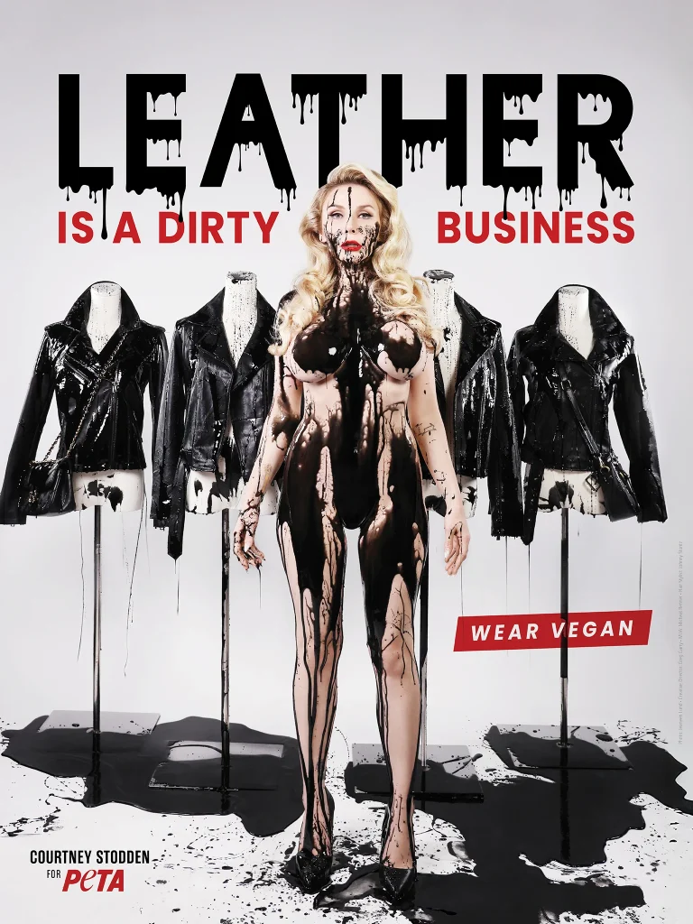 A poster of a naked woman standing with most of her body covered with black paint. Above her it is written "Leather Is A Dirty Business". In the background are leather jackets dripping with black paint.