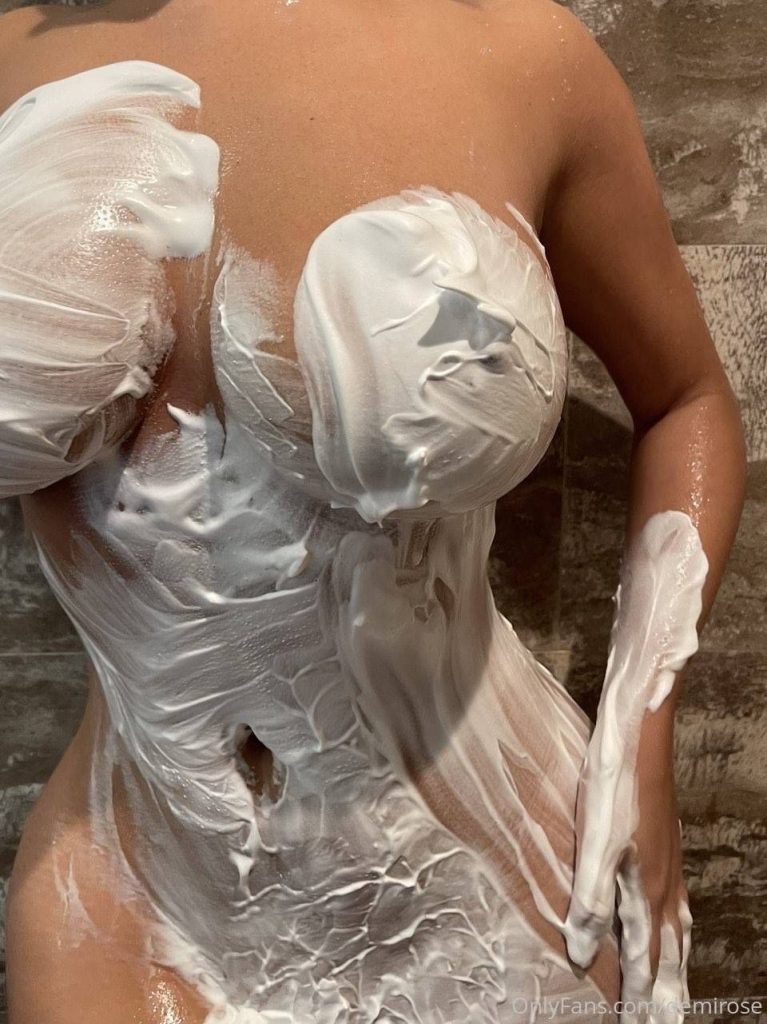 Close up of a woman's breast and stomach covered with cream