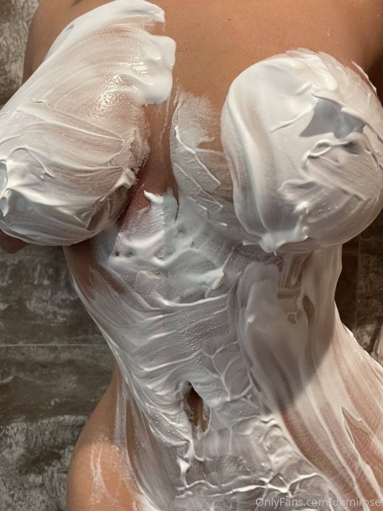 Close up of a voluptuous woman's breast and stomach covered with cream