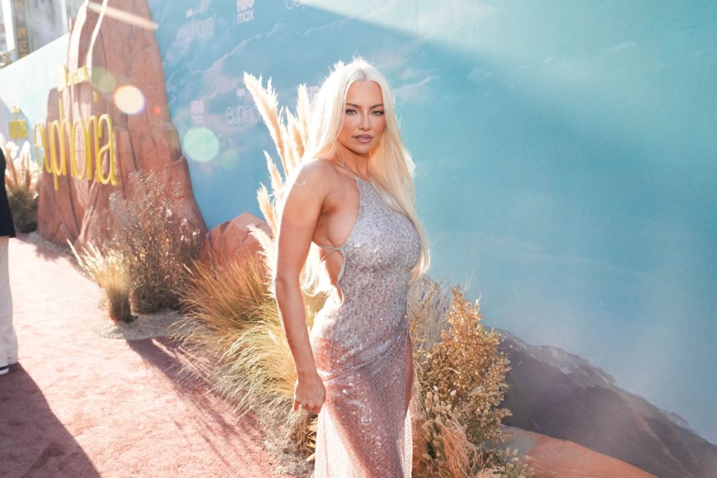 Close up of blonde woman in front of a blue sky background.