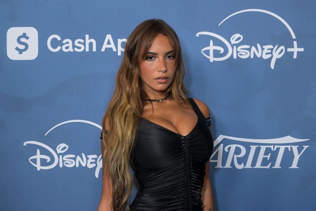 A woman in a black dress poses in front of a blue backdrop with Disney+, Variety, and Cash App logos.