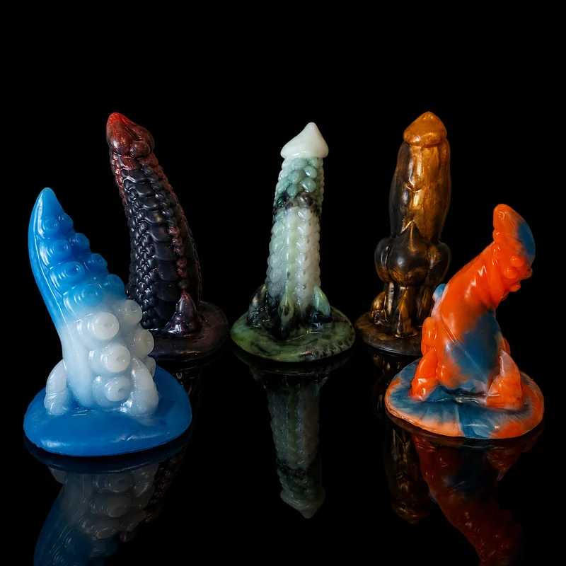 Five silicone adult toys with textured, fantasy-inspired designs in various colors, standing on a reflective black surface.